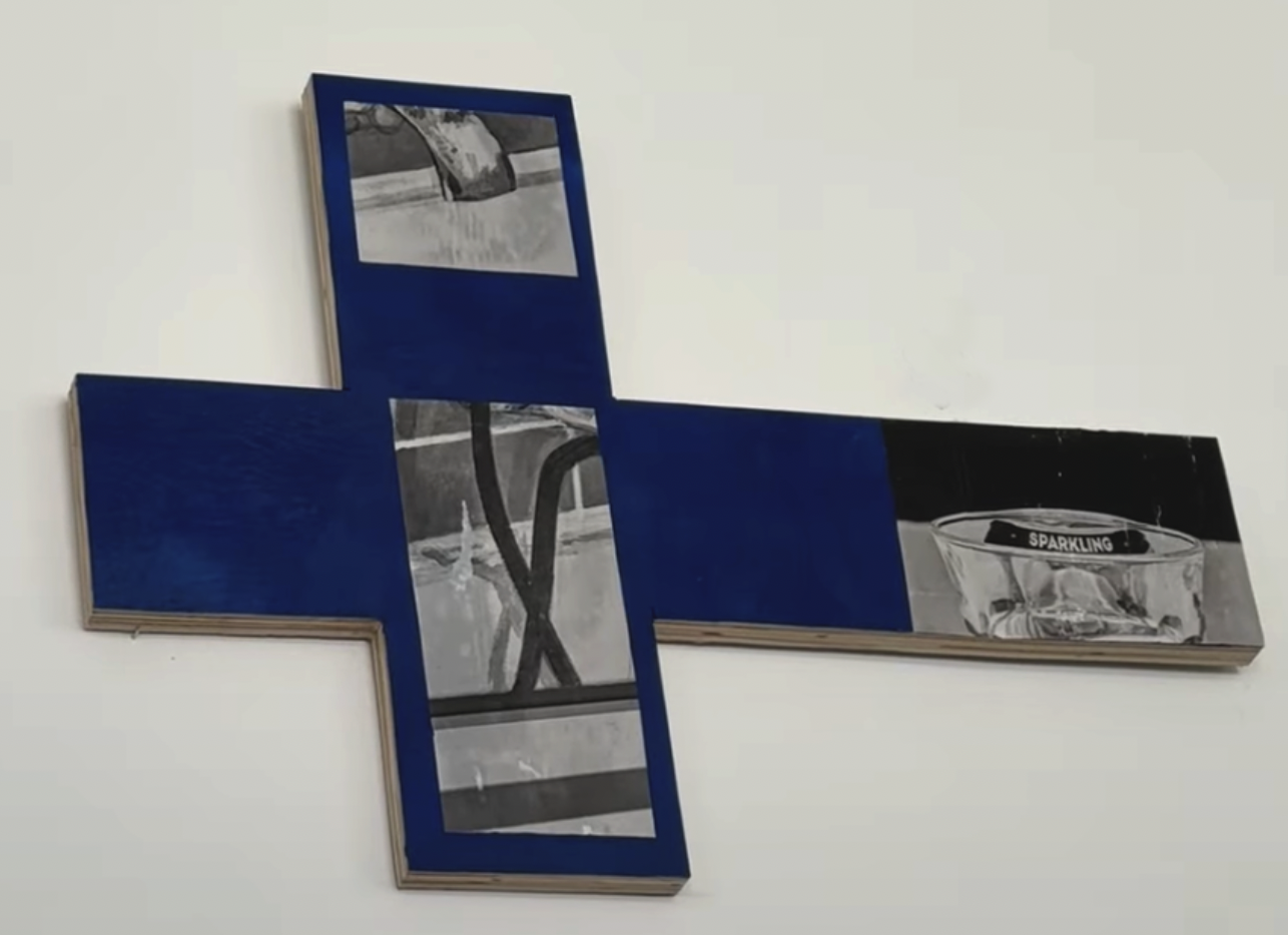 A blue cross-shaped artwork with black-and-white photographic details